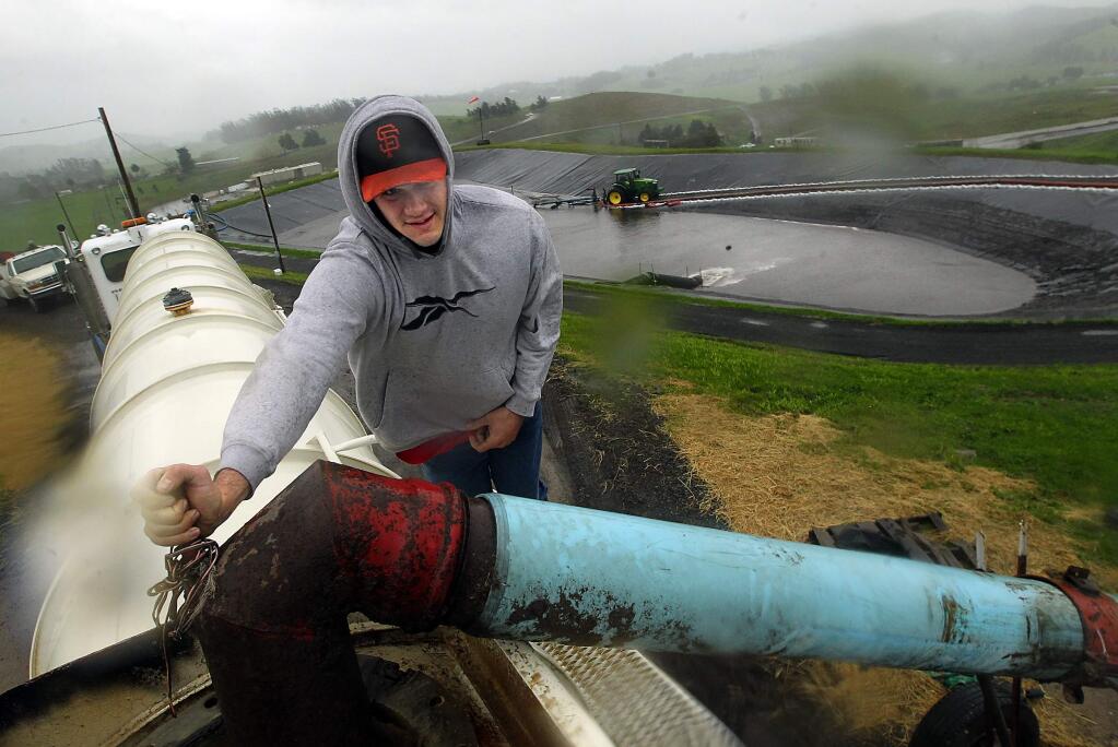 Jim Bidia stands atop a tanker as it fills with compost contact water caught in a holding pond at the Sonoma Compost Co. in February. (JOHN BURGESS/ PD FILE)