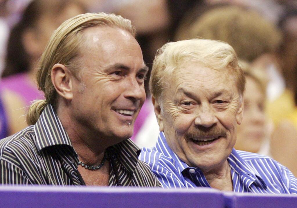 FILE - In this Aug. 23, 2005 file photo, Los Angeles Sparks owner Jerry Buss, right, and his son Johnny Buss watch a WNBA game against the Minnesota Lynx in Los Angeles, Calif. A battle over control of the Los Angeles Lakers among the late Jerry Buss's children is over after an agreement was reached to have Jeanie Buss serve as controlling owner of the storied NBA basketball franchise. Documents filed Monday, March 27, 2017 in Los Angeles Superior Court state that Jim and Johnny Buss have agreed that their sister will serve as the controlling owner for the rest of her life. (AP Photo/Chris Carlson, File)