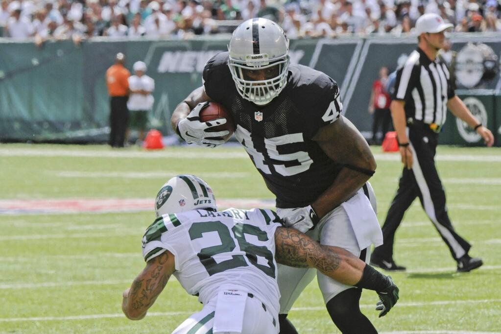 Oakland Raiders' Marcel Reece (45) avoids a tackle by New York Jets' Dawan Landry (26) during the first half of an NFL football game Sunday, Sept. 7, 2014, in East Rutherford, N.J. (AP Photo/Bill Kostroun)