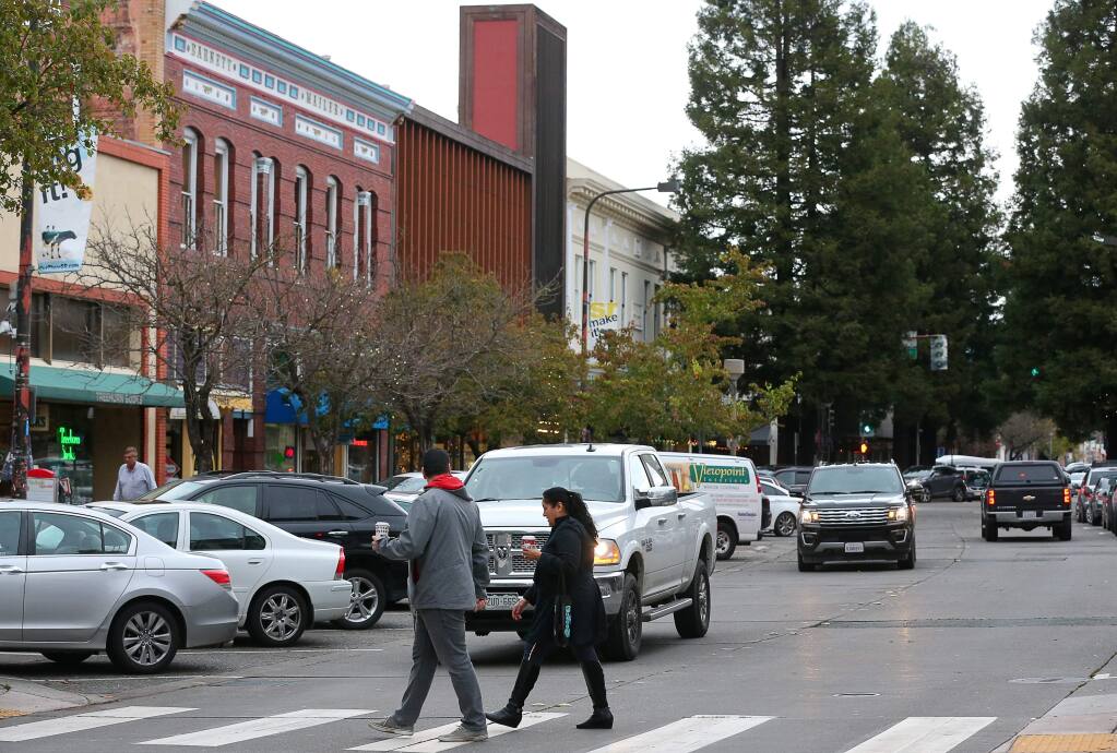 Pedestrians walk across Fourth Street in downtown Santa Rosa on Thursday, Dec. 5, 2019. (Christopher Chung/The Press Democrat)