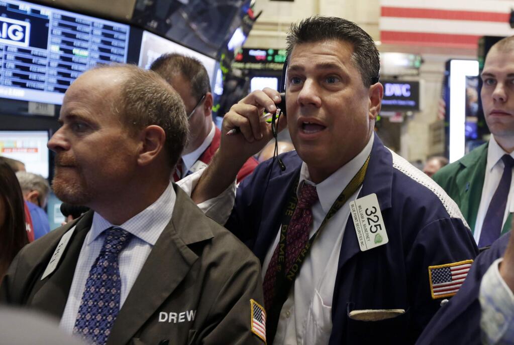 William McInerney, right, works with fellow traders on the floor of the New York Stock Exchange Wednesday, Sept. 17, 2014. (AP Photo/Richard Drew)