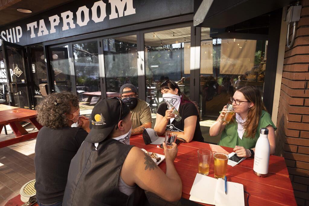 Friends share a beer and some appetizers on the opening day of the new Flagship taproom in Santa Rosa on Monday, June 1, 2020. (photo by John Burgess/The Press Democrat).