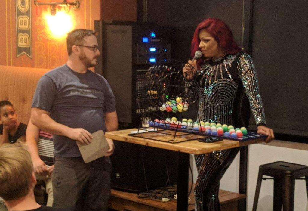 BINGO! - Kimber Rose (right) banters with a winner at Sauced BBQ's monthly Drag Queen Bingo event.