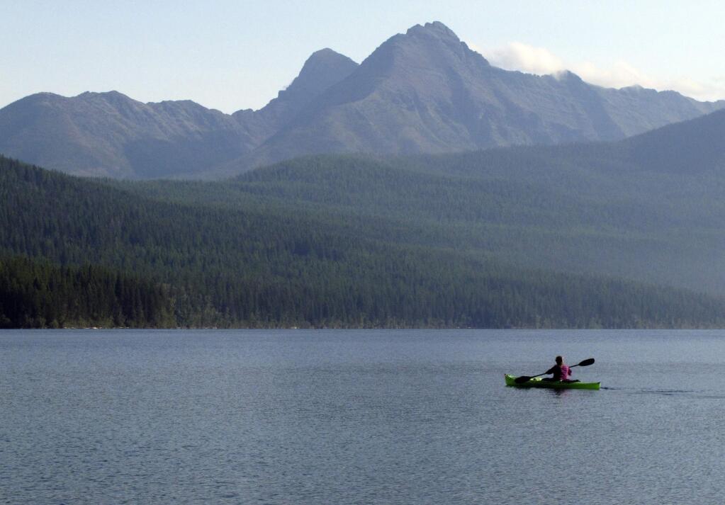 FILE - In this Sept. 6, 2013, file photo, a woman kayaks on Kintla Lake in Glacier National Park, Mont. A grizzly bear attacked and killed a 38-year-old mountain biker Wednesday, June 29, 2016, as he was riding along a trail just outside the national park, Montana authorities said. (AP Photo/Matt Volz, File)