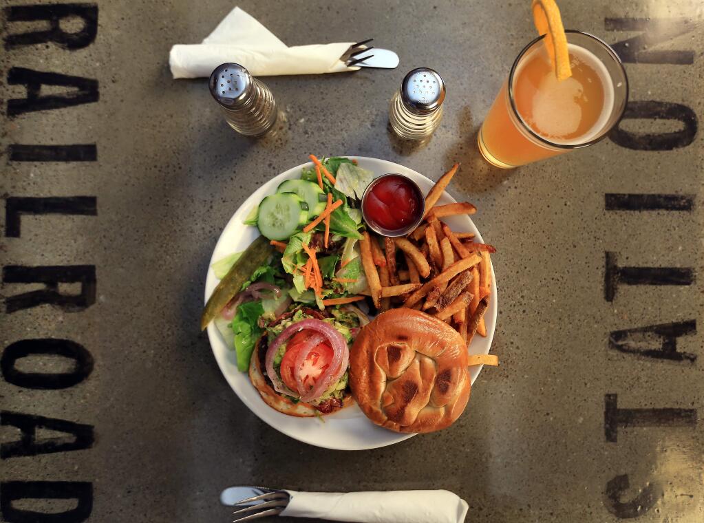 The Standard Burger at the Railroad Station Bar and Grill, garnished with avocado, onions, fresh tomatoes and a side salad with fries, Wednesday Oct. 8, 2014 in Cloverdale. (Kent Porter / Press Democrat) 2014