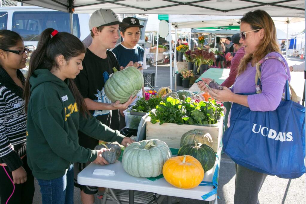 Julie Vader/Special to the Index-TribunePeddling Altimira produceStudents (from left) Lisbeth Pacheco, Jennifer Leon, Ashton Kirby and Rafa Garcia help their first customer purchase a green pumpkin at the Altamira Middle School horticulture program booth at the Sonoma Valley Certified Farmers Market, Friday, Oct. 7.