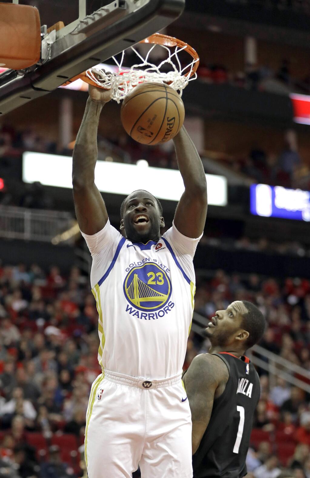 Golden State Warriors' Draymond Green (23) dunks the ball as Houston Rockets' Trevor Ariza (1) watches during the first half of an NBA basketball game Thursday, Jan. 4, 2018, in Houston. (AP Photo/David J. Phillip)