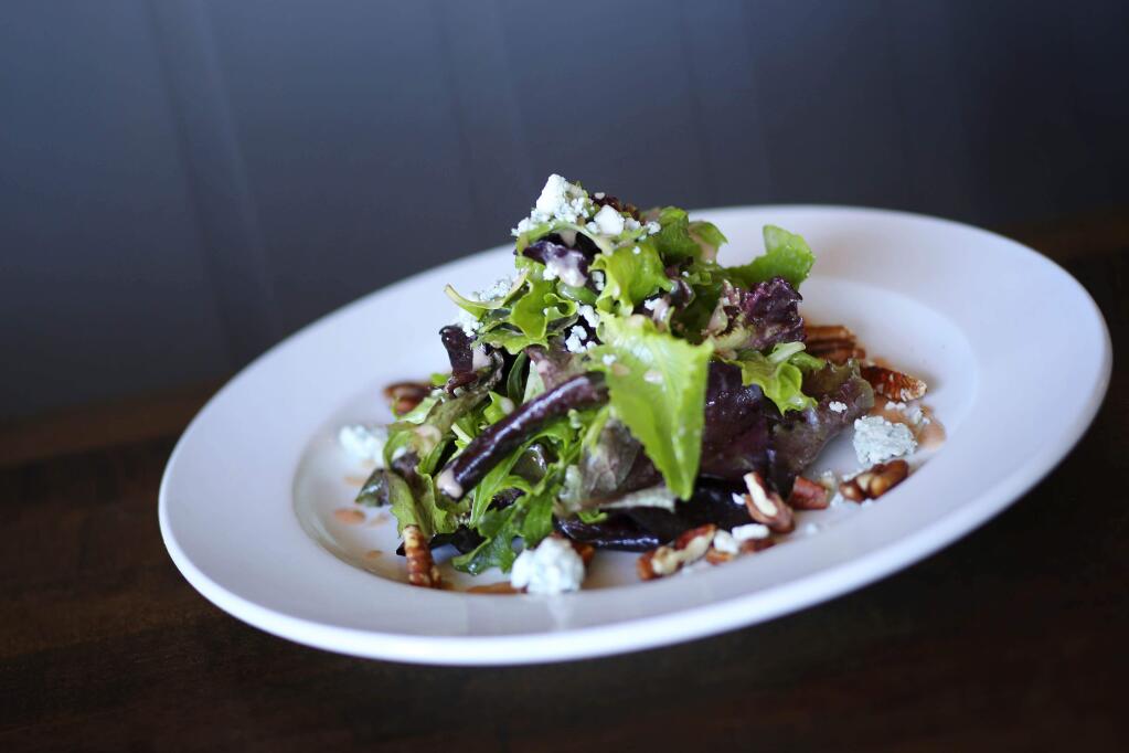 A simple mixed green salad can be dressed up with seasonal additions, such as  toasted pecans and  blue cheese. (Conner Jay / The Press Democrat)