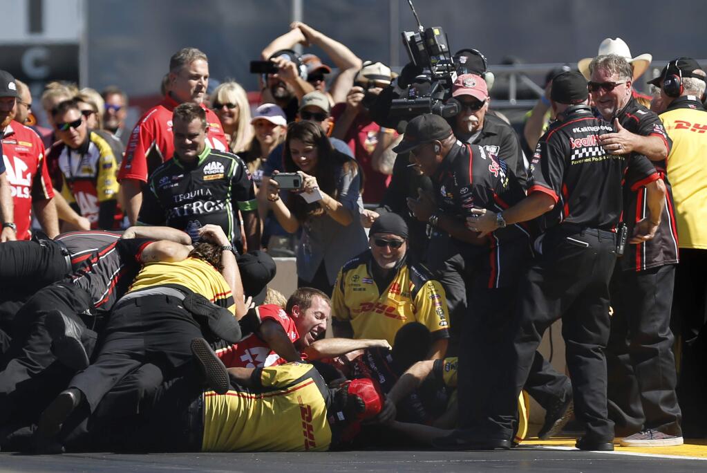Members of J.R. Todd's crew react after he won the Top Fuel finals driving a SealMaster dragster against Richie Crampton during the Toyota NHRA Sonoma Nationals at Sonoma Raceway on Sunday, July 31, 2016. (BETH SCHLANKER / The Press Democrat)