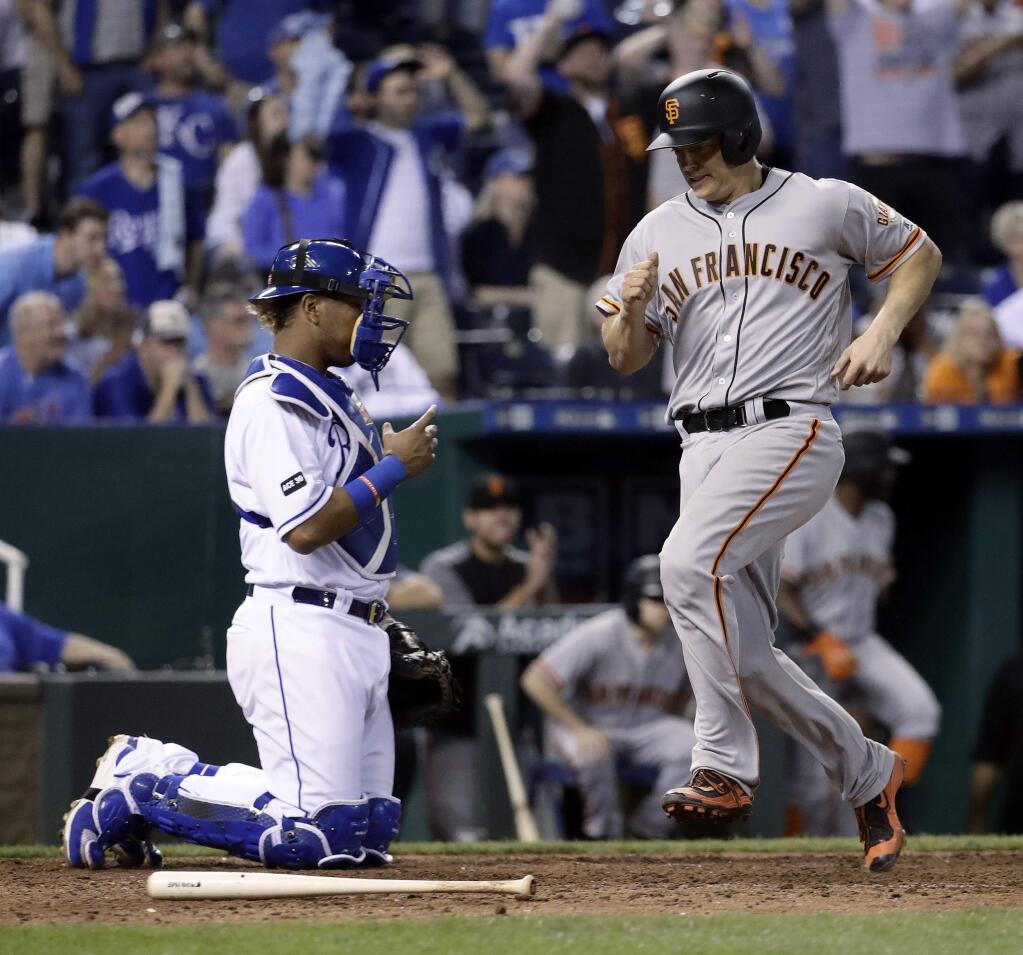 San Francisco Giants' Nick Hundley scores past Kansas City Royals catcher Salvador Perez on a single by Joe Panik during the 11th inning of a baseball game Tuesday, April 18, 2017, in Kansas City, Mo. The Giants won 2-1. (AP Photo/Charlie Riedel)