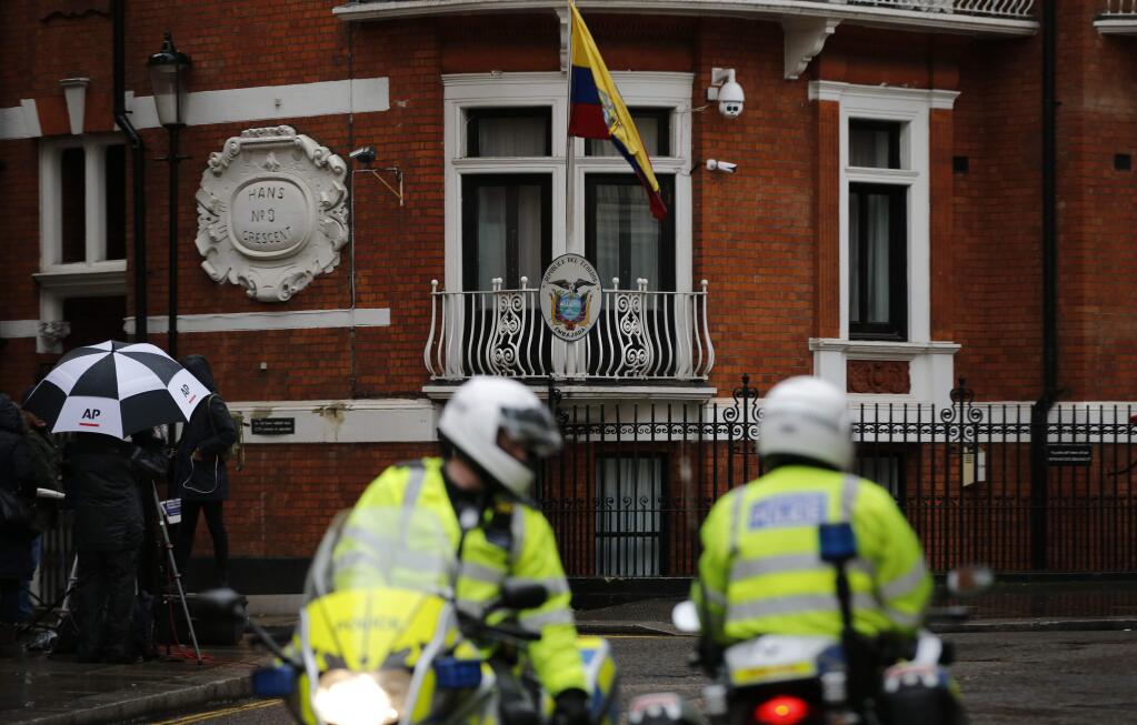 Police motorcyclists briefly stop outside the Ecuadorian embassy in London, Tuesday, Feb. 13, 2018. A British judge is set to decide Tuesday whether to quash or uphold an arrest warrant for WikiLeaks founder Julian Assange, who has spent more than five years evading the law inside Ecuador's London embassy. Assange's lawyers argue that it's no longer in the public interest to arrest him for jumping bail in 2012 and seeking shelter in the embassy to avoid extradition to Sweden, where prosecutors were investigating allegations of sexual assault and rape made by two women. He denied the allegations.(AP Photo/Alastair Grant)