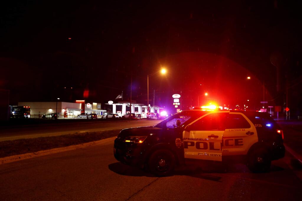 Police cars surround a Kum & Go gas station on East Chestnut Expressway in Springfield, Mo., after a shooting late Sunday, March 15, 2020. (Nathan Papes/The Springfield News-Leader via AP)