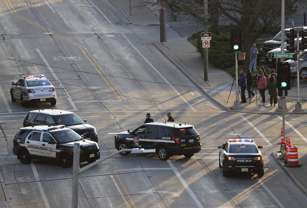 In this Wednesday, May 15, 2019 photo, authorities investigate the scene of a shooting at the Valley Transit Center in Appleton, Wis. A firefighter responding to a medical emergency was killed in the shooting at a Wisconsin bus station that left several others injured, officials said. (Dan Powers/The Post-Crescent via AP)