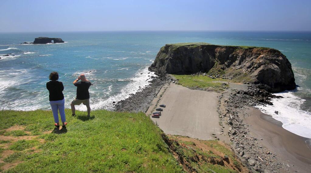 Seattle residents Deanna Perry and Doug Staab enjoy the view of Arch Rock, left, and Goat Rock at Goat Rock beach on the Sonoma Coast in Jenner, Wednesday April 13, 2016. (Kent Porter / Press Democrat)