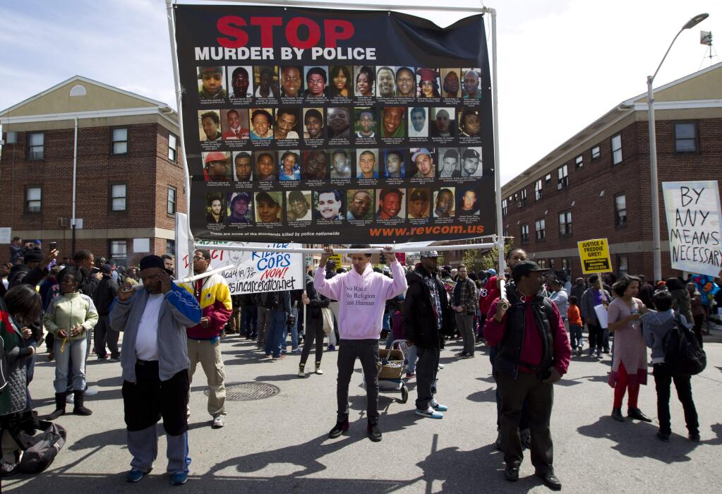 Demonstrators protest in the streets as they march for Freddie Gray to Baltimore's City Hall, Saturday, April 25, 2015. Gray died from spinal injuries about a week after he was arrested and transported in a police van. (AP Photo/Jose Luis Magana)