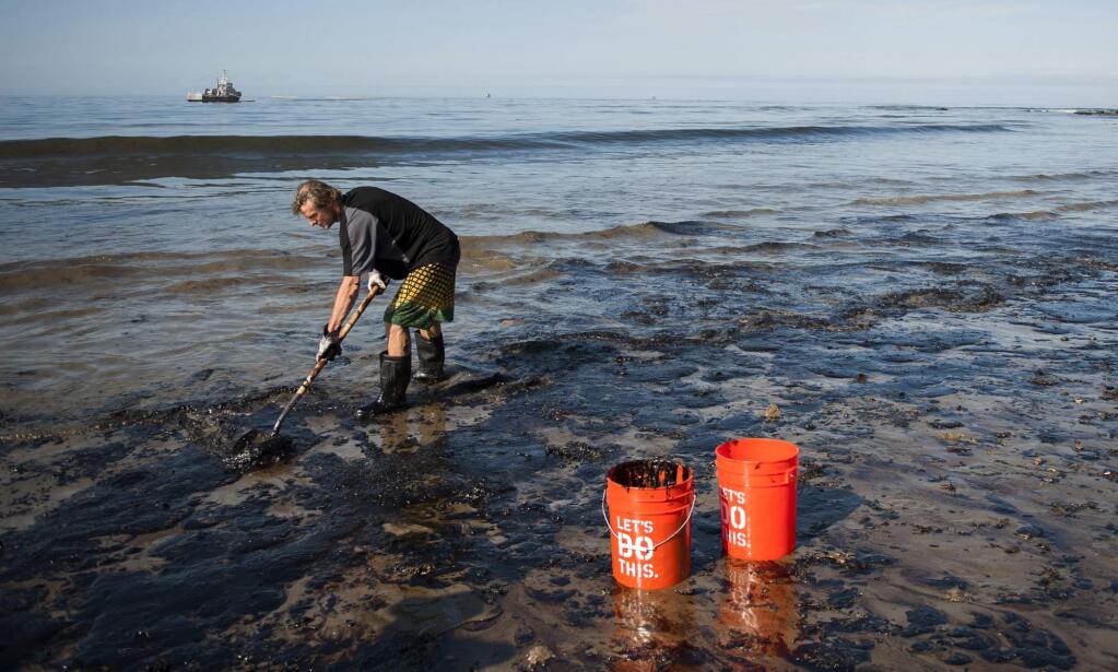 A man shovels up oil on a section of beach about a mile east of Refugio State Beach, Calif., Wednesday, May 20, 2015. A broken onshore pipeline spewed oil down a storm drain and into the ocean for several hours Tuesday before it was shut off. (Kenneth Song/The News-Press via AP) MANDATORY CREDIT; SANTA MARIA TIMES OUT