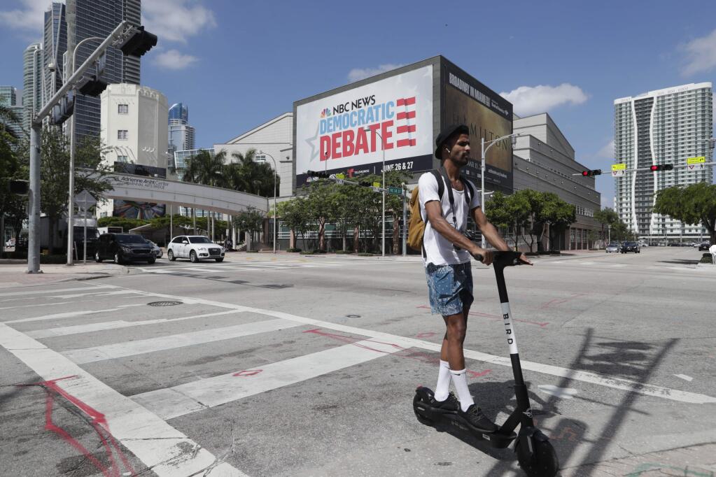 A billboard advertises the Democratic presidential debates across from the Knight Concert Hall at the Adrienne Arsht Center for the Performing Arts Monday, June 24, 2019, in Miami. (AP Photo/Lynne Sladky)
