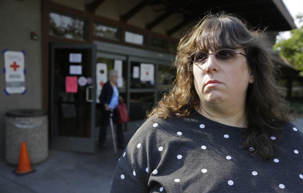 Jessica Tunis stands outside a Red Cross evacuation center Wednesday, Oct. 11, 2017, in Santa Rosa, Calif as she searched for her missing mother, Linda Tunis, who was living at Journey's End mobile home park when wildfires struck. Linda Tunis died in the Tubbs fire. (AP Photo/Eric Risberg)