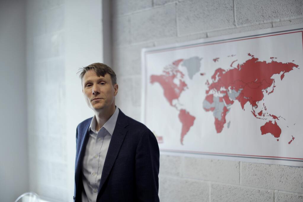 The founder and CEO of 'My Nametags' Lars Andersen, originally from Norway, poses for photographs by a map showing in red their global sales coverage, at his business premises in London, Wednesday, May 23, 2018. Starting Friday, May 25, 2018, My Nametags and most other companies that collect or process the personal information of EU residents must comply with the new General Data Protection Regulation, which the EU calls the most sweeping change in data protection rules in a generation. (AP Photo/Matt Dunham)