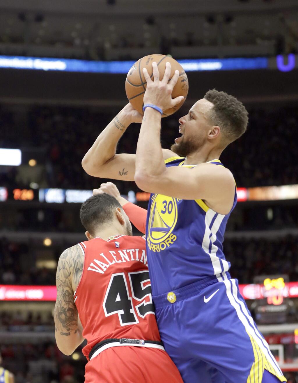 Golden State Warriors' Stephen Curry (30) shoots and draws a foul from Chicago Bulls' Denzel Valentine during the first half of an NBA basketball game Wednesday, Jan. 17, 2018, in Chicago. (AP Photo/Charles Rex Arbogast)