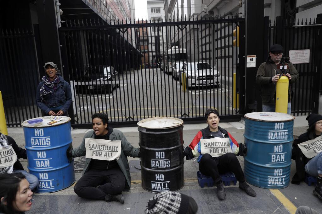 Demonstrators block an entrance to the Immigration and Customs Enforcement offices Wednesday, Feb. 28, 2018, in San Francisco. A top immigration official said Wednesday that about 800 people living illegally in Northern California were able to avoid arrest because of a weekend warning that Oakland Mayor Libby Schaaf put on Twitter.(AP Photo/Marcio Jose Sanchez)
