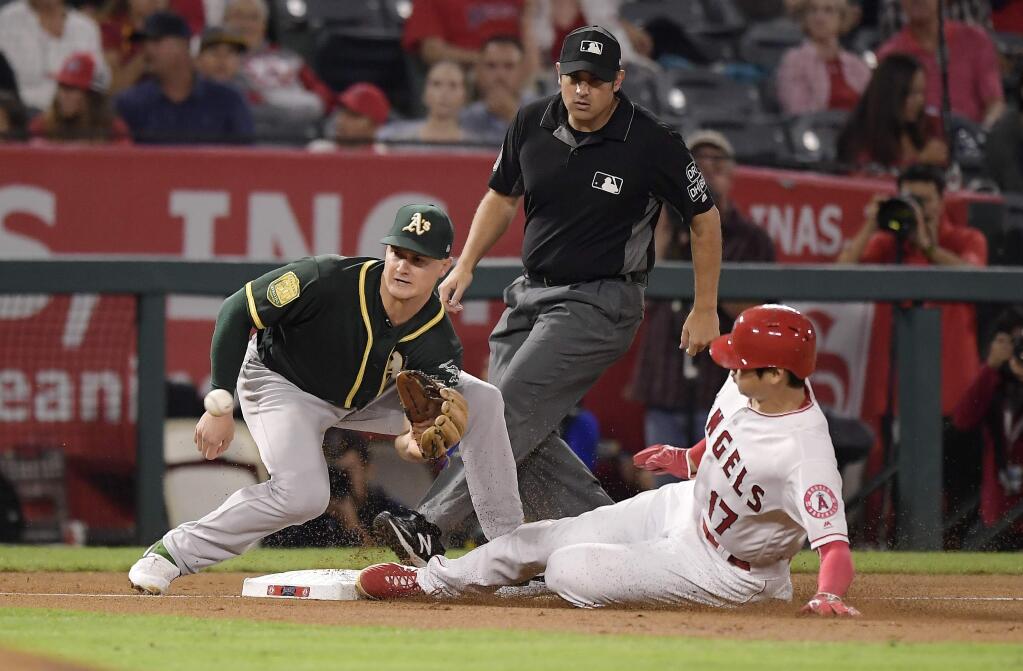 Los Angeles Angels' Shohei Ohtani, right, steals third as Oakland Athletics third baseman Matt Chapman takes a late throw from home during the second inning Friday, Sept. 28, 2018, in Anaheim. (AP Photo/Mark J. Terrill)