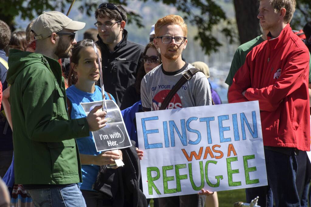 People stand together holding placards during the March for Science day in Geneva, Switzerland, Saturday, April 22, 2017. Thousands of people are expected to attend March for Science events around the world to promote the understanding of science and defend it from various attacks, including U.S. government budget cuts. (Martial Trezzini/Keystone via AP)