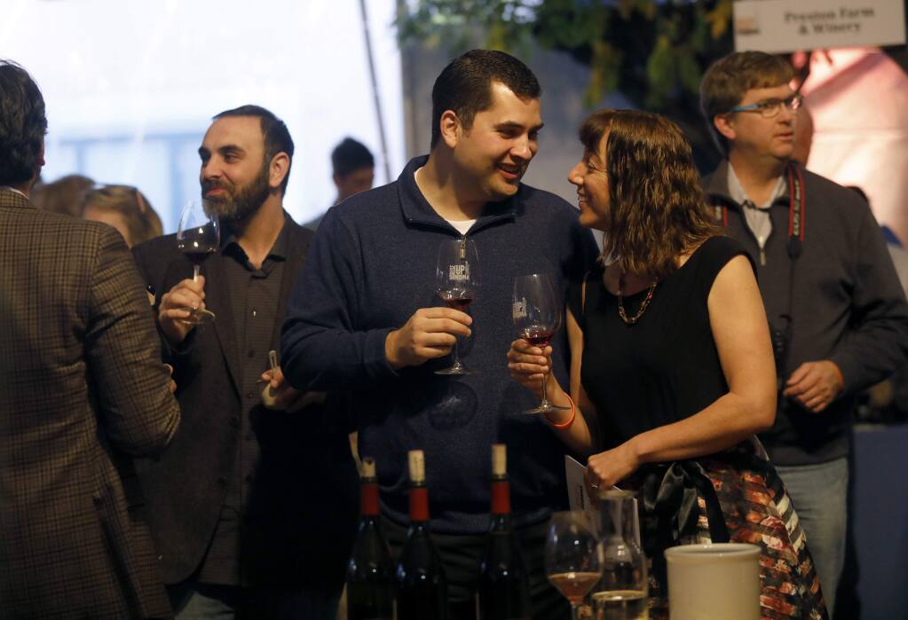 Jordan Burns and his wife Jennifer Branham-Burns enjoy a glass of wine during the RISE UP SONOMA culinary event at Sonoma Country Day School in Santa Rosa on Sunday, December 3, 2017. (BETH SCHLANKER/Press Democrat)