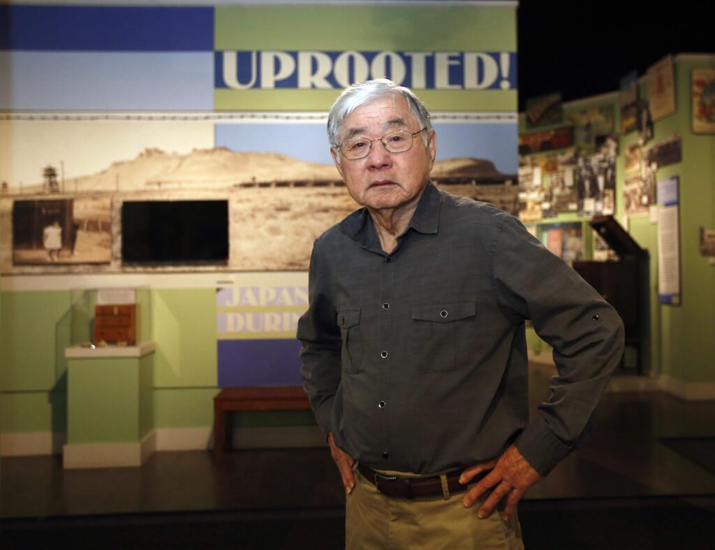 In this photo taken Tuesday, Feb. 11, 2020, Les Ouchida poses at the permanent exhibit titled 'UpRooted Japanese Americans in World War II' at the California Museum in Sacramento, Calif. Ochida, who is a docent for the exhibit, was a child when his family was forced to move in 1942 from their home near Sacramento to an internment camp in Arkansas. Assemblyman Al Muratsuchi, D-Torrence has introduced a resolution to apologize for the state's role in carrying out the federal government's internment of Japanese-Americans. A similar resolution will be brought up before the state Senate by Sen. Richard Pan, D-Sacramento. (AP Photo/Rich Pedroncelli)