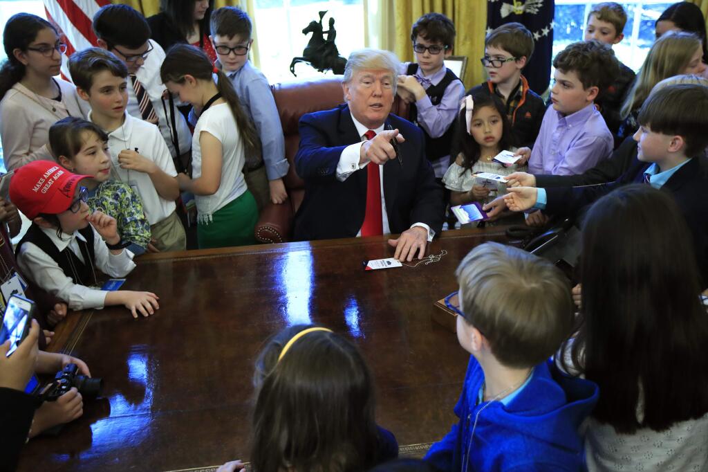 President Donald Trump is surrounded by kids in the Oval Office in celebration of 'Bring Our Daughters and Sons to Work Day' at the White House in Washington, Thursday, April 26, 2018. (AP Photo/Manuel Balce Ceneta)