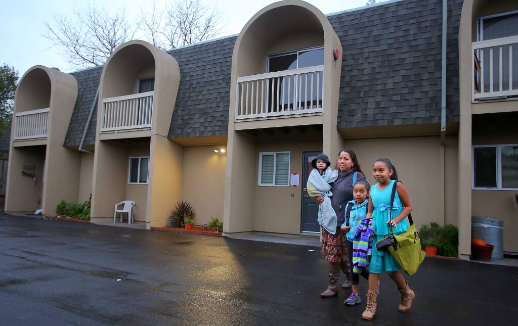 Elizabeth Nolasco walks with her children, Sebastian, 1, Nicole, 6, and Jennifer Sanchez, 8, as they leave their Hoen Avenue apartment for school on Jan. 16, 2015. The city of Santa Rosa ordered tenants to vacate the premises in January last year due to dangerous conditions, including extensive mold, rodent and cockroach infestations. (Photo by Christopher Chung\The Press Democrat)