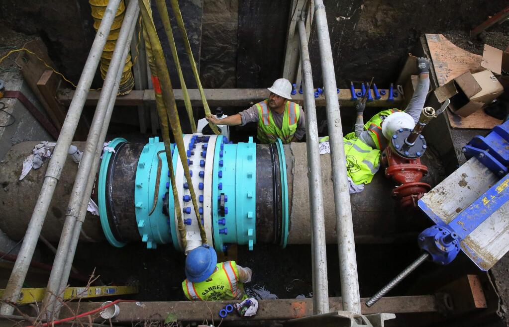 Workers with Ranger Pipelines, Inc., install an isolation valve on a water supply pipeline for the Sonoma County Water Agency, near First and A streets, in Santa Rosa, on Wednesday, February 1, 2017. (Christopher Chung/ The Press Democrat)