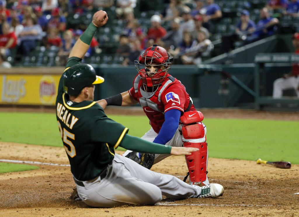 The Oakland Athletics' Ryon Healy is tagged out at home by the Texas Rangers' A.J. Jimenez on a fielder's choice hit into by Mark Canha in the ninth inning, Thursday, Sept. 28, 2017, in Arlington, Texas. Canha was safe at first on the play. (AP Photo/Tony Gutierrez)