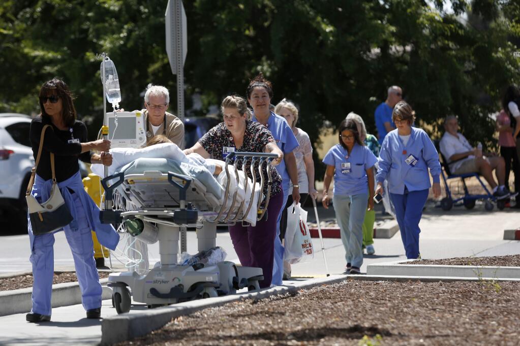 Kaiser Permanente patients and staff evacuate after an explosion involving a tanker truck carrying liquid oxygen at the Kaiser Permanente medical office building at 3975 Old Redwood Highway in Santa Rosa on Wednesday, July 18, 2018. (BETH SCHLANKER/ PD)