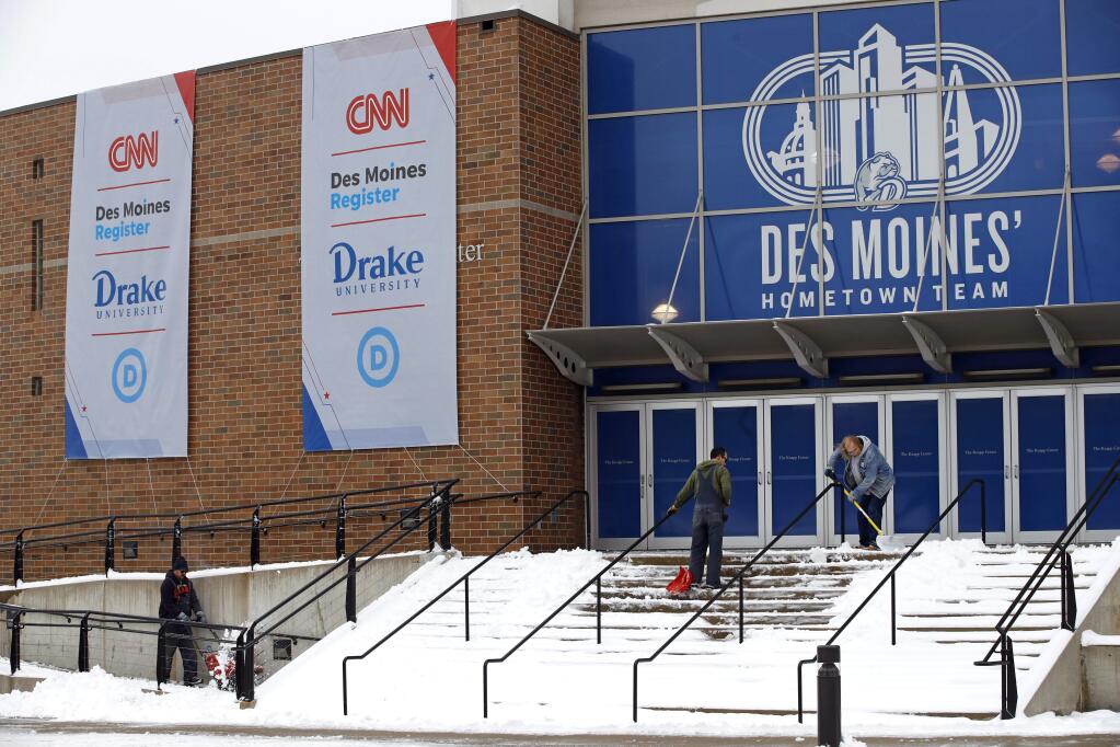 Workers clear snow outside a venue at Drake University in Des Moines in advance of a Democratic presidential primary debate scheduled for Tuesday. (PATRICK SEMANSKY / Associated Press)