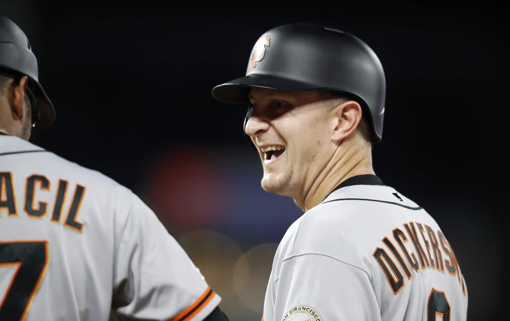 The San Francisco Giants' Alex Dickerson, right, jokes with first base coach Jose Alguacil after driving in the go-ahead run with a single off Colorado Rockies relief pitcher Wade Davis during the 10th inning Tuesday, July 16, 2019, in Denver. The Giants won 8-4 in 10 innings. (AP Photo/David Zalubowski)