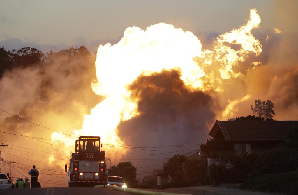 In this Sept. 9, 2010 file photo, a massive fire roars through a mostly residential neighborhood in San Bruno, Calif. Pacific Gas & Electric Co. pleaded not guilty Monday, Aug. 18, 2014, to charges in a new indictment that accuses the utility of lying to federal investigators looking into a fatal pipeline explosion in a San Francisco Bay Area neighborhood. (AP Photo/Paul Sakuma, File)
