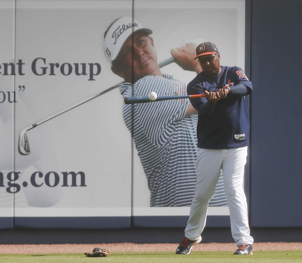 Houston Astros assistant hitting coach Alonzo Powell hits fly balls to his fielders before a spring training game against the Miami Marlins, Wednesday, March 29, 2017, in West Palm Beach, Fla. (AP Photo/John Bazemore)