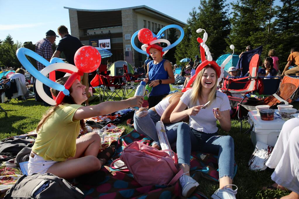 Abby Smits, 13, left, friend Jeremiah Kellison, 12, rear, and her sister Emma Smits, 16, right, attend the 4th of July Fireworks Spectacular event at the Green Music Center at Sonoma State University in Rohnert Park, California on Thursday, July 4, 2019. (BETH SCHLANKER/The Press Democrat)