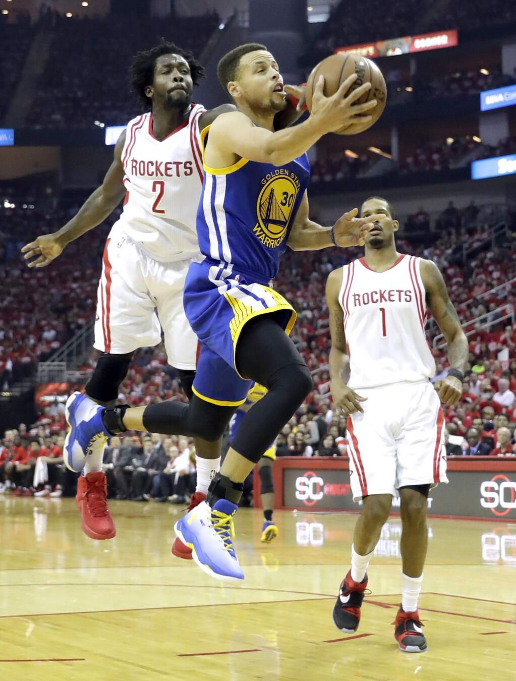 Golden State Warriors' Stephen Curry, center, is fouled on his way to the basket by by Houston Rockets' Patrick Beverley, left, as Houston's Trevor Ariza watches during the first half in Game 4 of a first-round NBA basketball playoff series, Sunday, April 24, 2016, in Houston. (AP Photo/David J. Phillip)