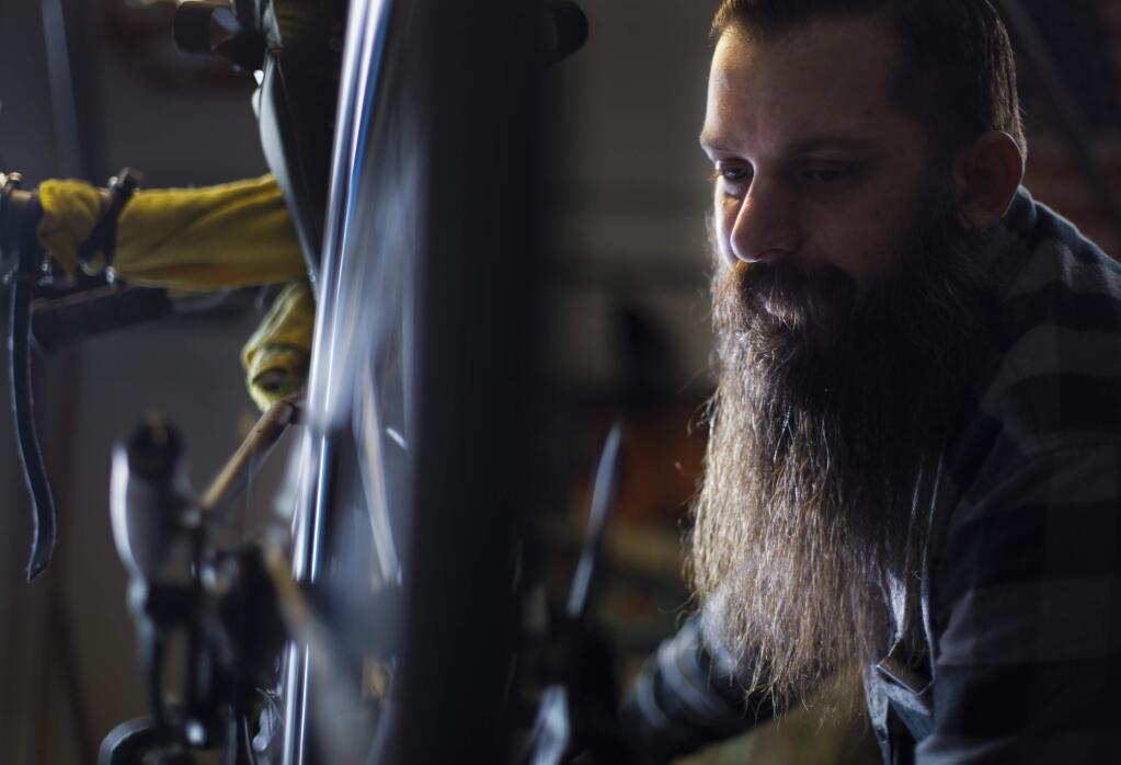 Petaluma, CA, USA. Tuesday, December 13, 2016._ Tim Nicholls, a bike repairman at Bruce Gordon Cycles, has been repairing bikes that he will donate to COTS. His program called 'Mending the Wheel' hopes to give the shelter 40 or 50 bikes for Christmas. (CRISSY PASCUAL/ARGUS-COURIER STAFF)