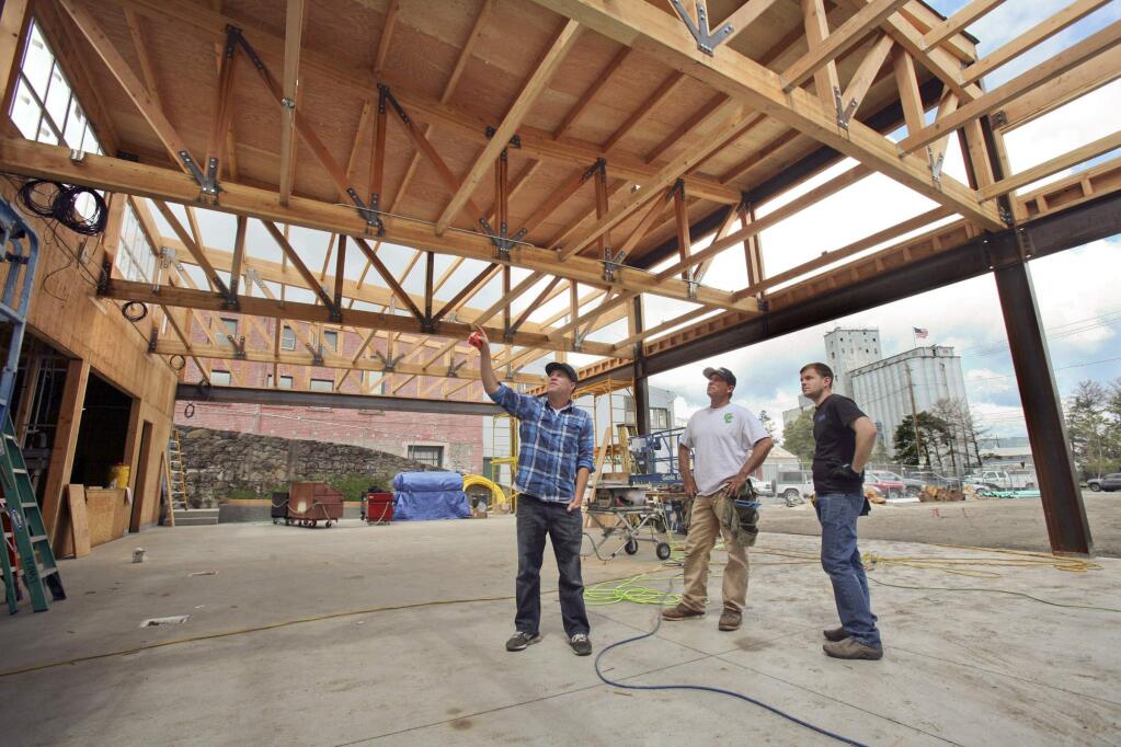 Brewster's Beer Garden owner Mike Goebel, left, talks to his contractor Dean Greisen of Greisen Construction and electrician Dan Lynch of Commercial Audio Video Solutions about TV placement during construction on Wednesday, April 27, 2016. (SCOTT MANCHESTER/ARGUS-COURIER STAFF)