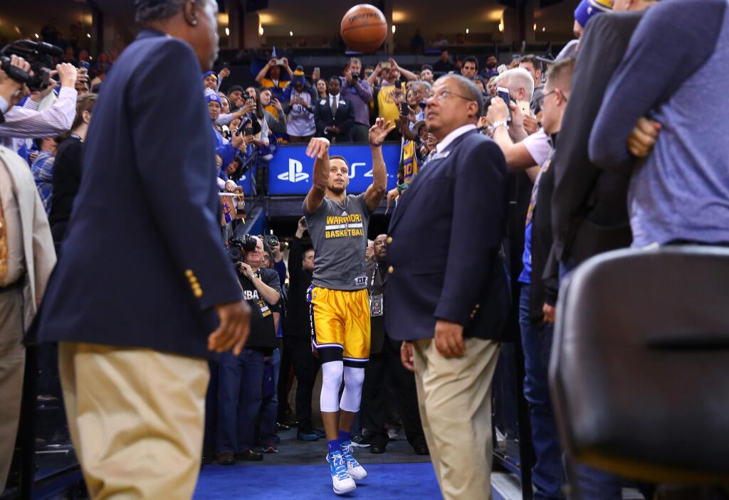 Golden State Warriors guard Stephen Curry shoots from the player tunnel after warming up for the game against the Los Angeles Lakers in Oakland on Tuesday, November 24, 2015. (Christopher Chung/ The Press Democrat)