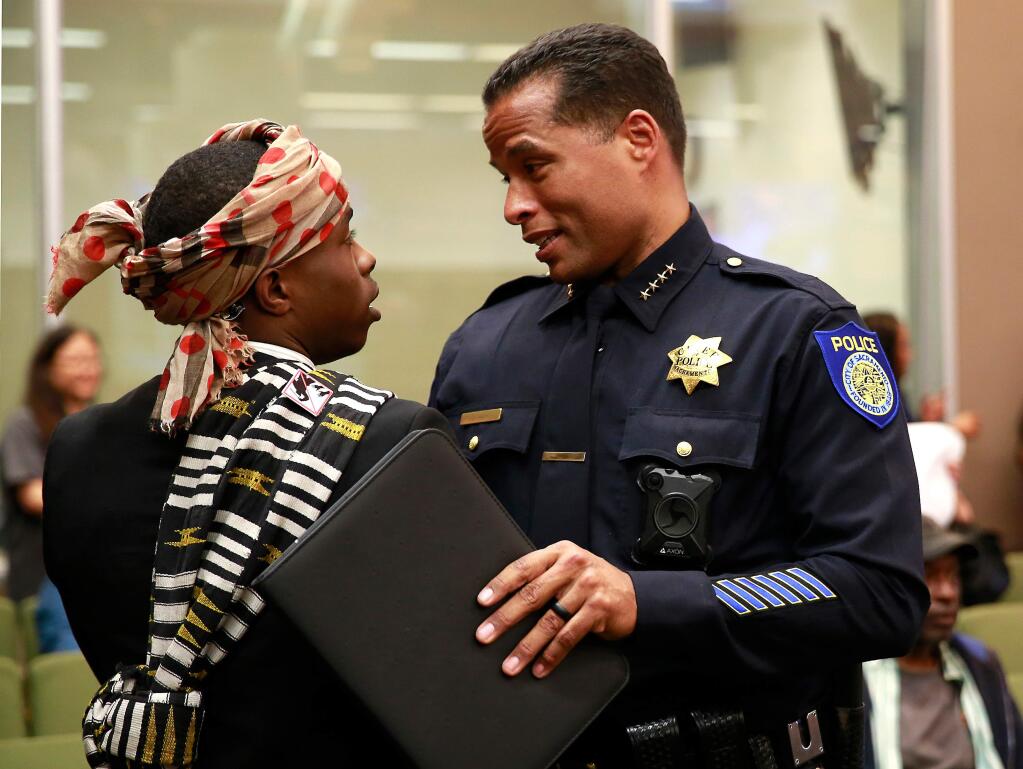 FILE--In this April 10, 2018, file photo, Stevante Clark, the brother of Stephon Clark, who was shot and killed by Sacramento police, talks with Sacramento Police Chief Daniel Hahn before a meeting of the Sacramento City Council in Sacramento, Calif. Clark was arrested on Thursday, April 19, 2018, and accused of making threats to commit a crime resulting in death or great bodily injury and telephoning 911 with the intent to annoy or harass. (AP Photo/Rich Pedroncelli, file)