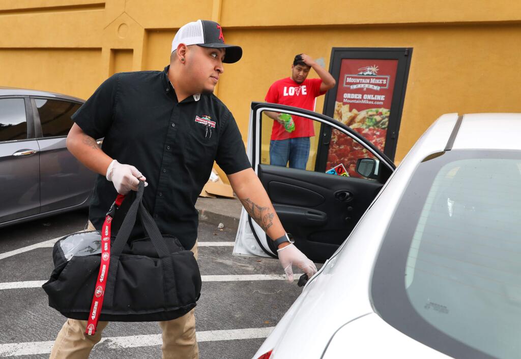Alfredo Meza prepares to make a delivery for Mountain Mike's Pizza in Santa Rosa on Monday, April 6, 2020. The owner of the pizza chain secured a Small Business Administration loan during the first round of funding.(Christopher Chung/ The Press Democrat)