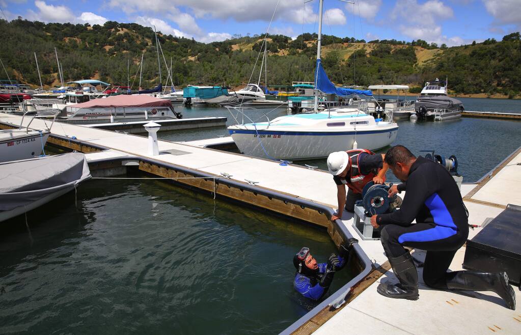 Odon Peralta, left, Filiberto Barron and Luis Vega work on putting the completing the new dock and boat slips at Lake Sonoma, on Friday, May 20, 2016. (Christopher Chung/ The Press Democrat)