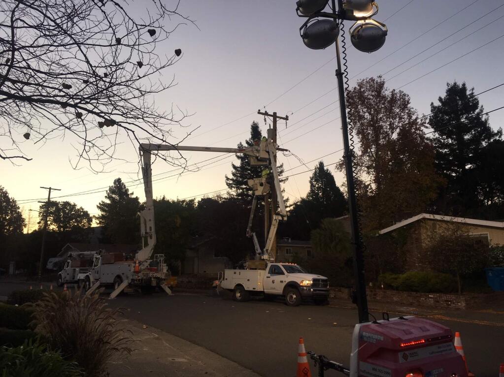 Workers replace a sheared pole on Creekside Road in Santa Rosa after a car slammed into it, Wednesday, Nov. 7, 2018. (CHRIS SMITH/ PD)