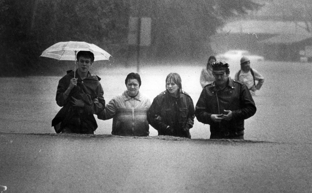 Residents of the Russian River wade their way to high ground as the river set a record for flooding. About 500 people were airlifted to Santa Rosa. (Chris Dawson/The Press Democrat, 1986)