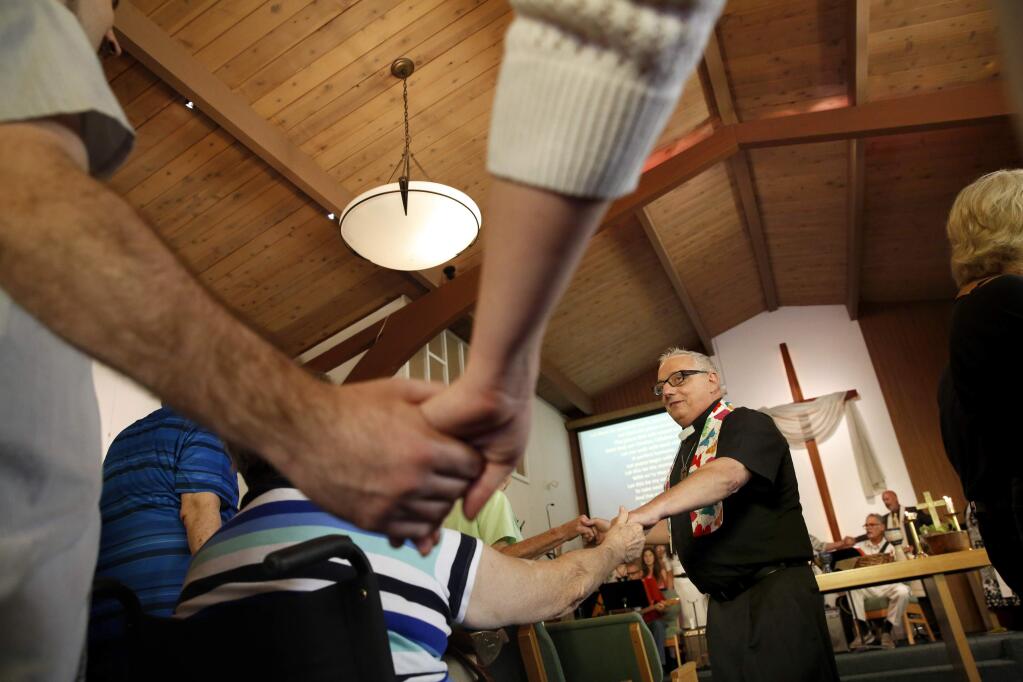 Members of the Lower Lake Community United Methodist Church, including Pastor John Pavoni, join hands and sing 'Let There Be Peace on Earth' with members of other area Methodist churches during a service at the Clearlake Community United Methodist Church on Sunday, August 21, 2016 in Clearlake, California . (BETH SCHLANKER/ The Press Democrat)