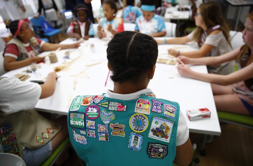 In this July 21, 2017 photo, badges are seen on the vest of a member of the Girl Scouts of Central Maryland as Girl Scouts participate in an activity introducing them to the world of robotics in Owings Mills, Md. The Girl Scouts of the USA is unveiling a major push this week into furthering the interest of girls in science, engineering, technology and math through 23 new badges, its largest addition of new badges in a decade. (AP Photo/Patrick Semansky)